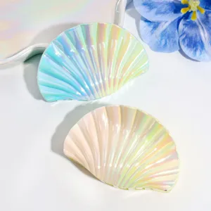 Dettaglio molletta per capelli a conchiglia sfumata, accessorio stile sirena perlato.
