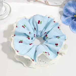 Blue checkered scrunchie detail view, sweet cherry print with double white lace trim decoration.