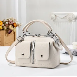 Elegante bolso Boston beige con asas dobles, bolsillos frontales y una práctica correa de hombro.