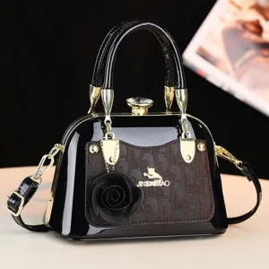 Borsa a mano in pelle verniciata nera con dettagli dorati, chiusura in cristallo e fiore.