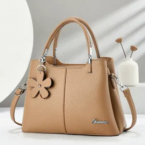 Elegante borsa a mano in pelle cachi con grazioso ciondolo a fiore, manico e tracolla.