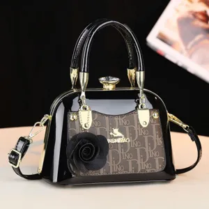Chic borsa a mano in pelle verniciata con motivo monogramma, ciondolo floreale e chiusura sicura.