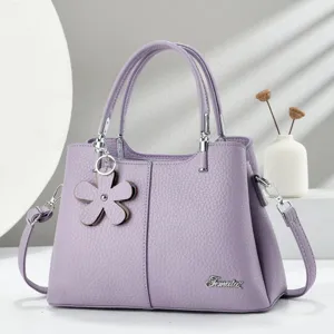 Borsa in pelle viola con motivo litchi e ciondolo a fiore, elegante vista di dettaglio dei metalli.