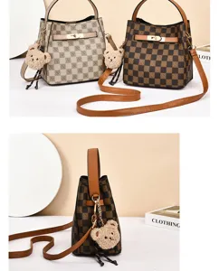 Vue détaillée du sac seau à carreaux classique, design contrasté élégant avec charm d'ours.
