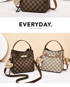 Sac seau à motif damier classique avec charmant pendentif en peluche et poignée élégante.