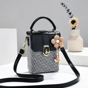 Compacte box crossbodytas met zwart-wit geweven patroon, stijlvolle handtas met sluiting.