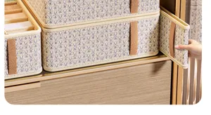 Detailopname van lade-ondergoedorganizer met praktische stoffen opbergdoos en handig handvat.