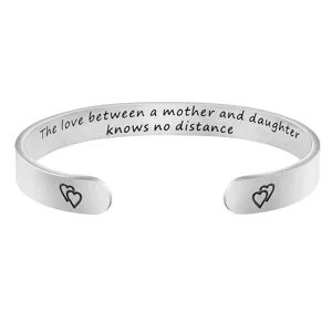 Detailed view of stainless steel open cuff bracelet featuring emotional mother daughter quote.