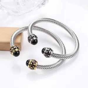 Stainless steel twisted cable cuff bracelet with black and gold checkered ends for men detail view.