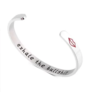 Gros plan detail du bracelet manchette en acier inoxydable avec gravure et motif de levres.
