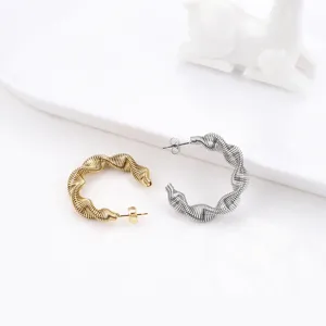 Detail view of trendy stainless steel spring twist hoop earrings, unique women's minimalist jewelry.