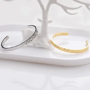 Detailed view of fashionable titanium steel hammered C-cuff bangles in silver and gold.