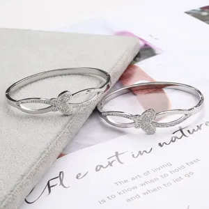 Stainless steel butterfly rhinestone bangle for women, chic interlocking cuff jewelry.