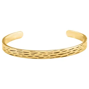 Close-up detail of the gold C-shaped open cuff bracelet featuring a textured hammered surface finish.