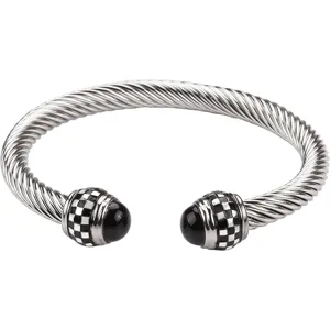 Stainless steel twisted cable cuff bracelet with checkered terminal details. Detail shot.