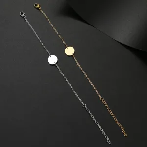 Detail shot of minimalist silver and gold chain bracelets featuring delicate round disc pendants.