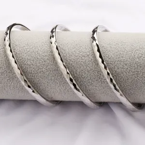 Gros plan détaillé de joncs ouverts argentés à facettes pour hommes, texture de coupe fine.