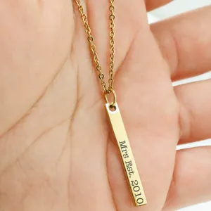 Photo détaillée d'un élégant collier en or personnalisé avec un pendentif barre.