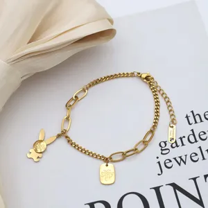 Detail view of a gold stainless steel paperclip chain bracelet featuring a cute rabbit charm.