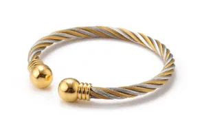 Vue détaillée d'un bracelet manchon torsadé bicolore en acier inoxydable avec billes dorées.