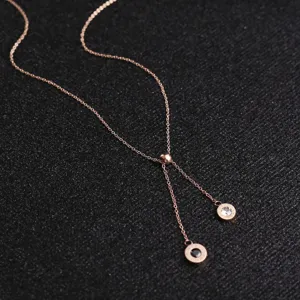 Collier en acier titane couleur or rose en Y avec deux pendentifs circulaires et fine chaîne.
