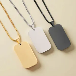 Stainless steel dog tag pendant detail showcasing gold, silver, and black minimalist design.