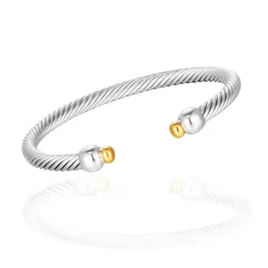 Bracelet jonc torsadé en acier inoxydable avec embouts boules dorés, élégant bijou ouvert.