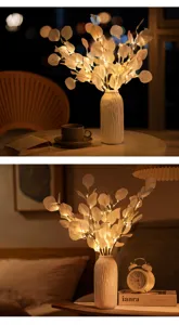 Detalle de lámpara de rama LED minimalista nórdica, hojas artificiales cálidas, decoración.