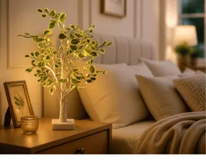 Detalle de la lámpara de árbol de abedul LED con ramas luminosas cálidas y hojas verdes.