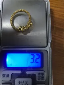 Gros plan détaillé de la bague en acier inoxydable torsadé montrant le poids sur balance.