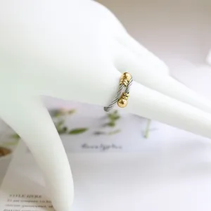 Bague en acier titane torsadé avec embouts sphériques plaqués or 18k, vue détaillée.