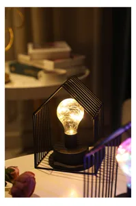 Minimalistisch ijzeren huis LED nachtlampje detail, gezellige warme gloeilamp decor voor slaapkamer.