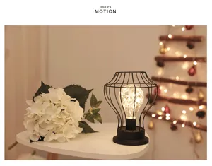 Scènedetail van retro ijzerdraad decoratieve tafellamp met gloeiende led-lamp en witte bloem.