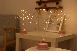 Primer plano de la lampara de mesa LED creativa con forma de paraguas y luz calida acogedora.