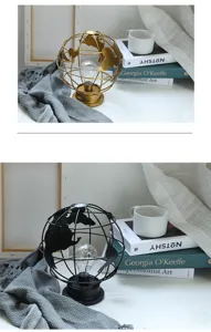 Detailopname van de ijzeren globenachtlamp met LED-lamp, boeken en gezellige deken.