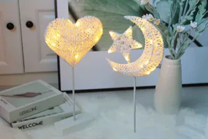 Gedetailleerd overzicht van verlichte rattan hart en ster maan LED nachtlampjes binnen.