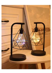 Detail van moderne ijzeren LED-tafellamp met geometrische diamantlamp en warme sfeerverlichting.