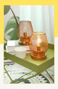 Detalle de la lámpara de mesa LED de malla metálica en oro rosa con luz cálida y diseño elegante.