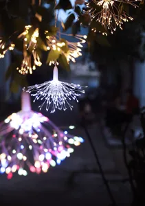 Hangende vuurwerk LED lichterketting gloeiend in buitentuin, decoratief koperdraad ontwerp.