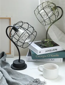 Creatieve metalen bureaulamp met flexibele hals en warm LED-licht in een gezellige opstelling.