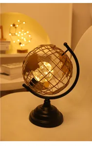 Detailaufnahme van de creatieve metalen wereldbol tafellamp die warm brandt met LED-lampjes.