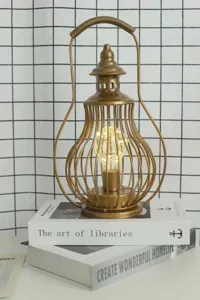Vintage golden iron LED table lamp, retro hollow lantern night light for home decor.