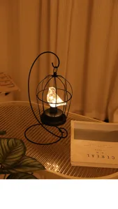 Gedetailleerd overzicht van een creatieve ijzeren vogelkooi LED nachtlamp, warme sfeer.