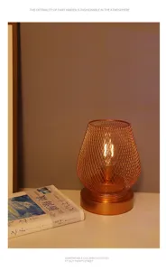 Vista detallada de lámpara de mesa alambre oro rosa, iluminación LED cálida para dormitorio acogedor.