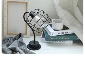 Gedetailleerd overzicht van de draadkooi bureaulamp, moderne zwarte metalen decoratie voor slaapkamer.