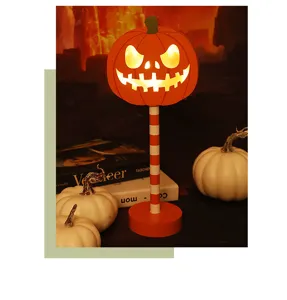 Detail van Halloween LED pompoen nachtlampje met gloeiend gezicht en gestreepte standaard.