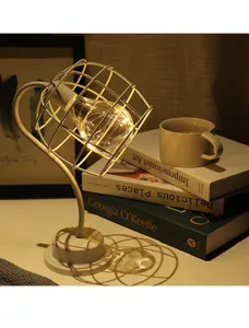 Creatieve USB tafellamp met wit metalen kooi ontwerp en warm LED licht voor op het bureau.