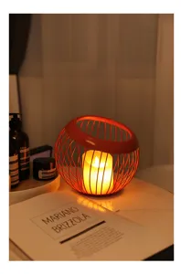 Primo piano di un cesto in filo metallico rosso e portacandele per un'atmosfera accogliente.