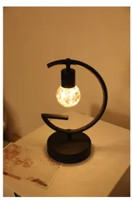 Close-up van minimalistische ijzeren G-vormige nachtlamp met warme LED-gloeilamp.