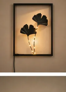 Lampada da parete in ferro battuto con foglie di ginkgo, cornice nera con luci LED calde.